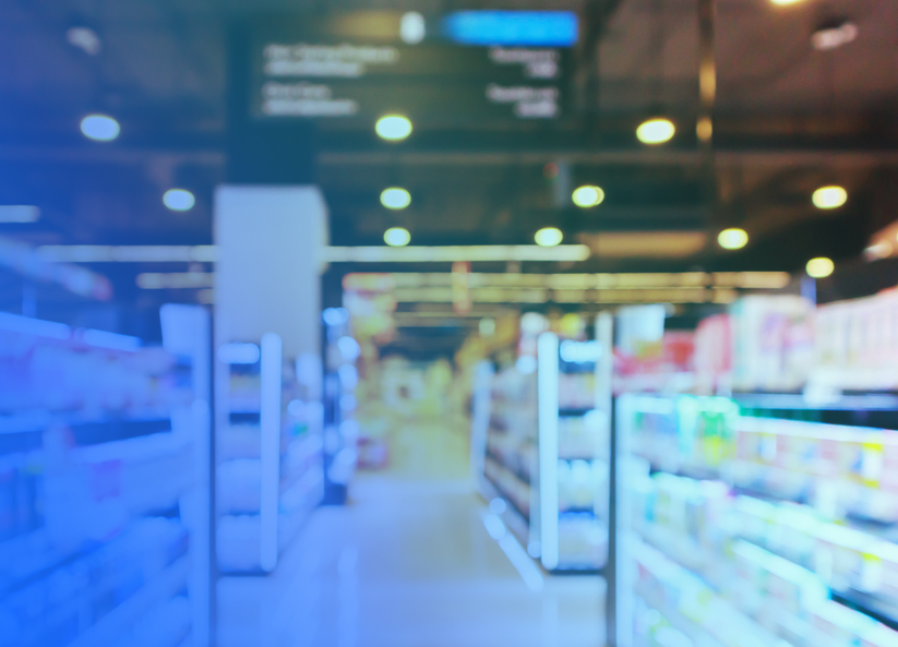 Blurred retail store aisle with product shelves and overhead lighting