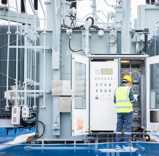 Field engineer operating an electrical substation control panel representing energy infrastructure management and maintenance