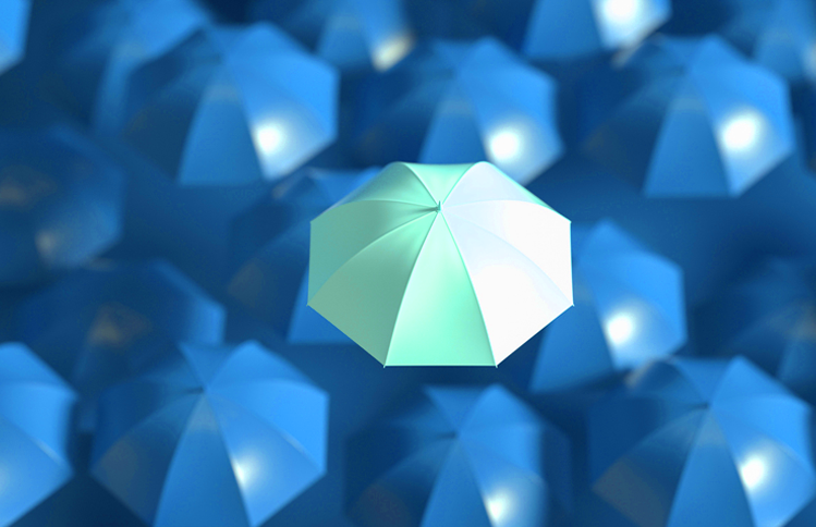 An overhead, close-up shot of numerous blue umbrellas, with one light-green umbrella in the center that stands out from the rest. All the umbrellas are open and facing upward.