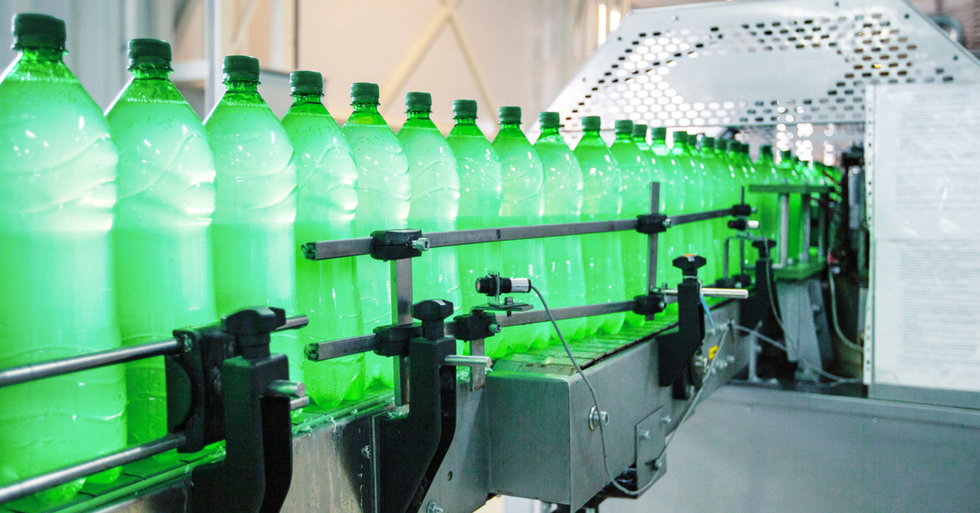 plastic beverage bottles on a conveyer belt in a manufacturing facility